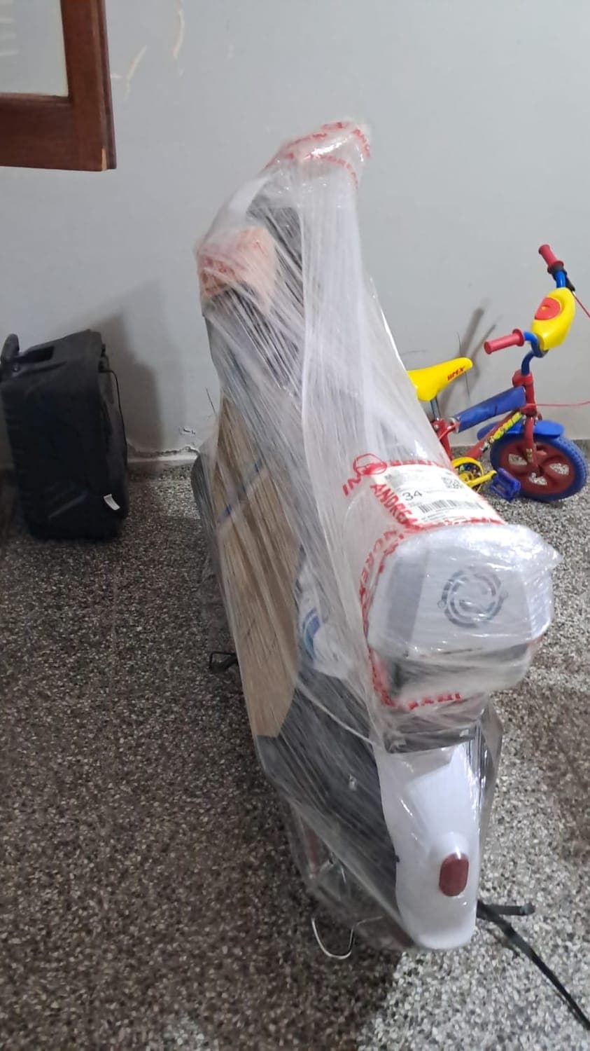 Moto eléctrica blanca embalada, recién entregada en la casa del cliente